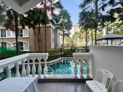 Luxurious poolside view from a private balcony in a tropical resort setting.