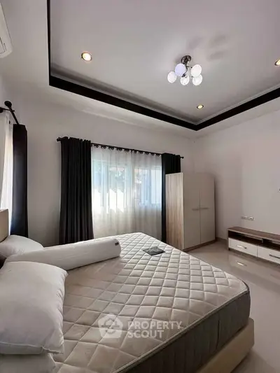 Spacious bedroom with modern decor and natural light, featuring a comfortable bed and stylish wardrobe.