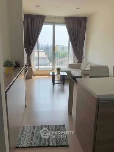 Bright living room with large window and modern furniture, offering a city view.