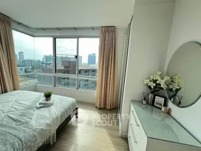 Bright bedroom with city view, featuring large windows and modern decor.