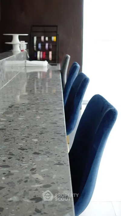 Stylish modern kitchen with sleek marble countertop and elegant blue chairs