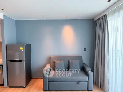 Modern living room with sleek gray sofa and stylish refrigerator