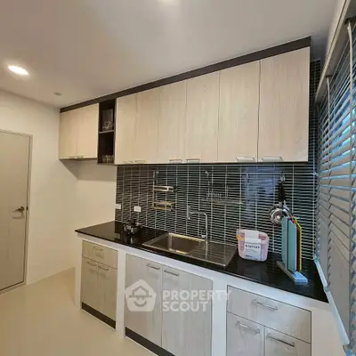 Modern kitchen with sleek cabinetry and stylish backsplash in a contemporary home.