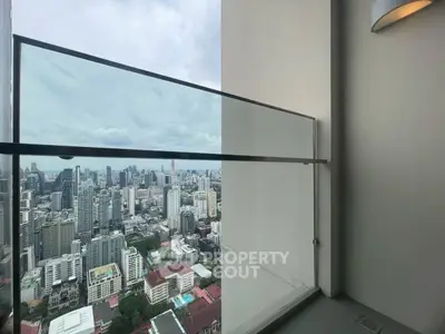 Stunning cityscape view from modern high-rise balcony with glass railing.