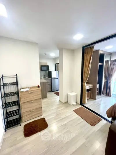 Modern apartment interior with open layout, featuring a compact kitchen and cozy living area.