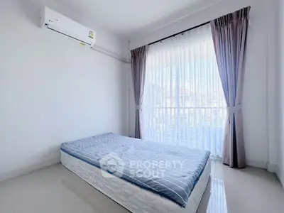 Bright bedroom with large window and air conditioning in modern apartment