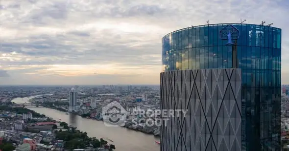 Stunning aerial view of modern skyscraper with panoramic cityscape and river in the background.
