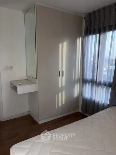 Cozy bedroom with natural light and modern wardrobe in a stylish apartment.