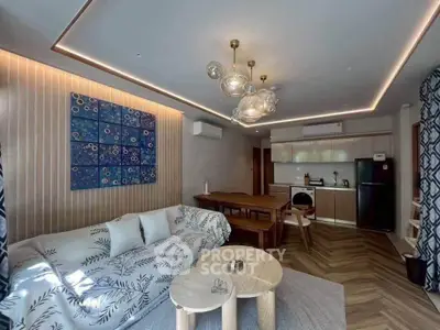 Modern living room with stylish decor and open kitchen layout, featuring elegant lighting and contemporary furniture.