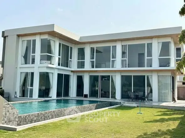 Luxurious modern villa with expansive glass windows and private pool, perfect for upscale living.