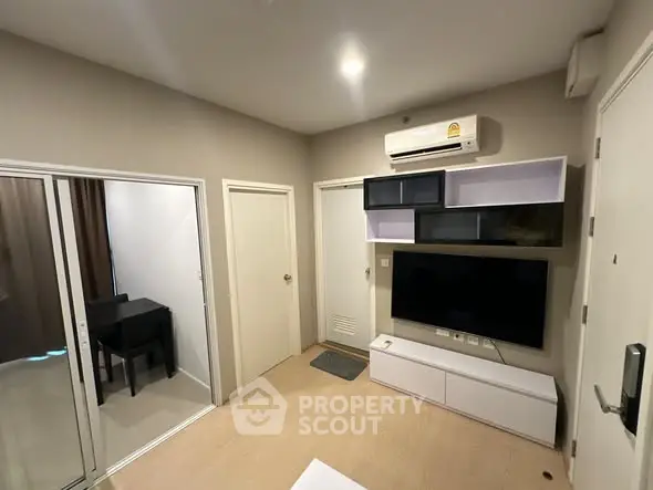 Modern living room with sleek TV unit and air conditioning in a cozy apartment.