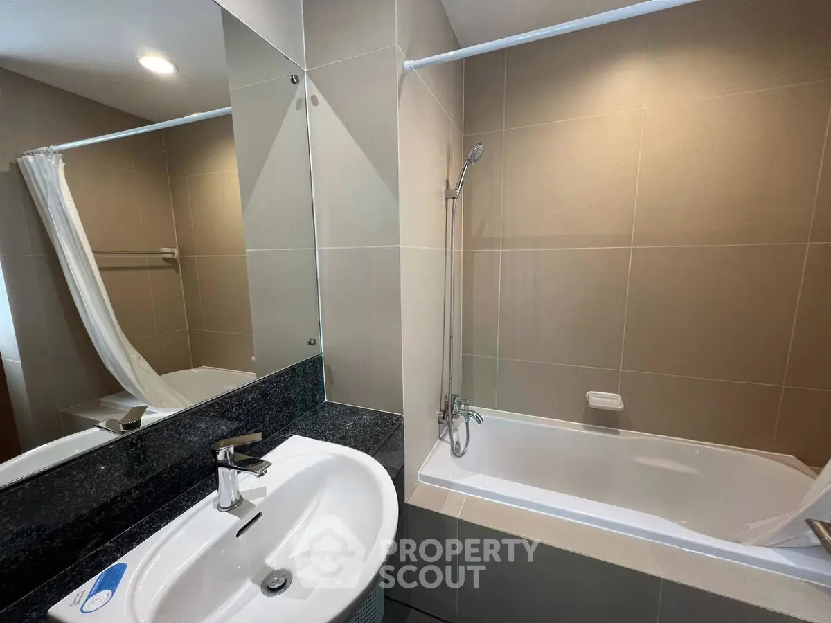 Modern bathroom with sleek design and bathtub in contemporary apartment.