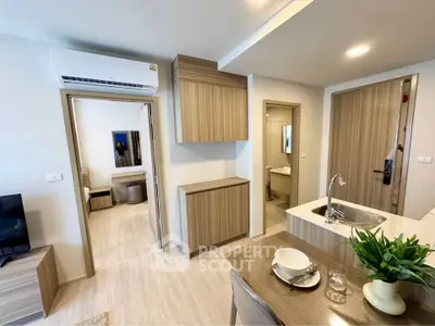 Modern open-plan living area with stylish kitchen and cozy dining space in a contemporary apartment.