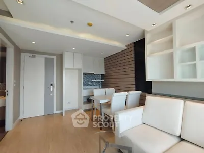 Modern living room with sleek design and open kitchen layout in a stylish apartment.
