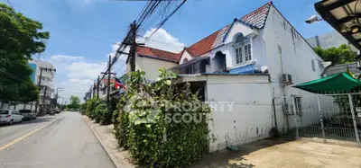 Charming residential street with unique architectural homes and lush greenery.