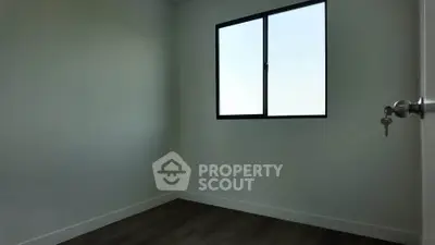 Minimalist empty room with large window and wooden floor, perfect for customization.