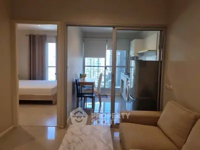 Modern apartment interior with living room, bedroom, and kitchen featuring a washing machine and dining area.