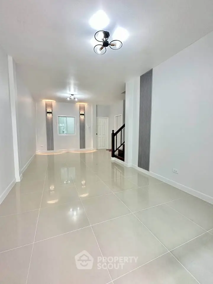 Spacious modern living room with elegant lighting and glossy tiled flooring.