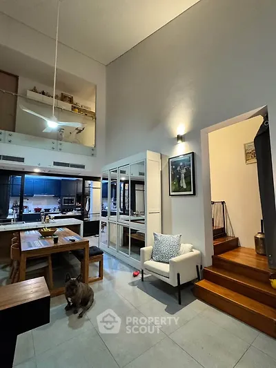 Spacious modern living room with high ceilings and open kitchen layout, perfect for entertaining.