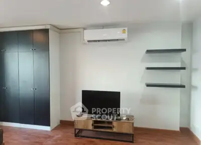Modern living room with sleek black cabinets and mounted air conditioner