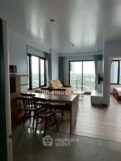 Spacious living room with city view, modern furniture, and natural light.