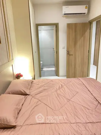 Cozy bedroom with ensuite bathroom and modern air conditioning unit.