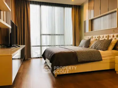 Luxurious bedroom with modern decor and large window offering city view.