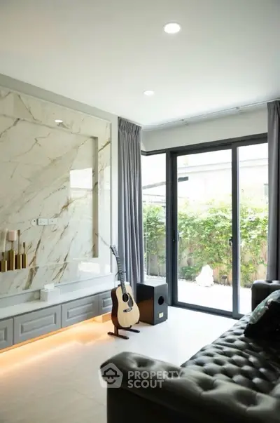 Stylish living room with marble accent wall and garden view