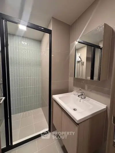 Modern bathroom with sleek shower and stylish vanity in contemporary apartment.