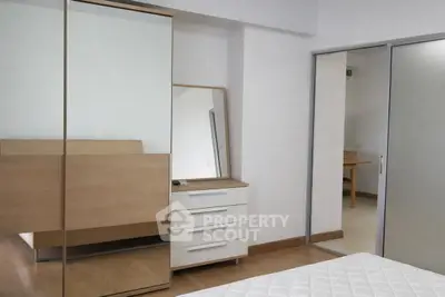 Modern bedroom with sleek mirrored wardrobe and minimalist design