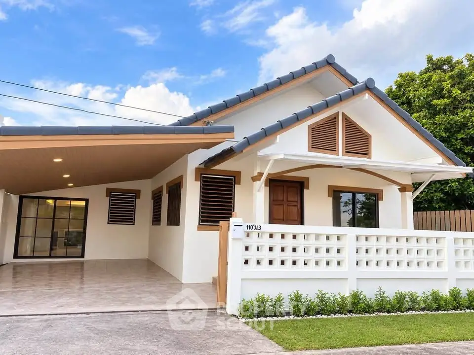 Charming single-story house with modern design, spacious carport, and lush greenery, perfect for family living.