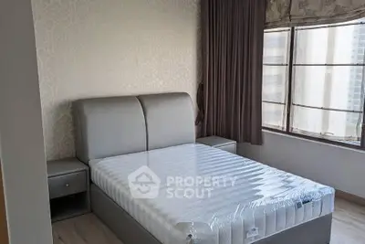 Modern bedroom with upholstered bed and large windows in a high-rise apartment.