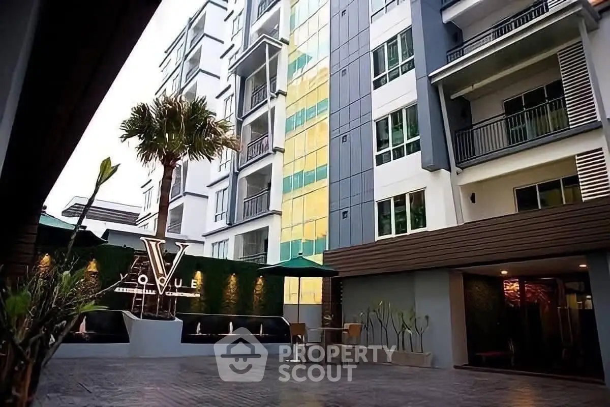 Modern condominium exterior with stylish facade and lush landscaping in urban setting.