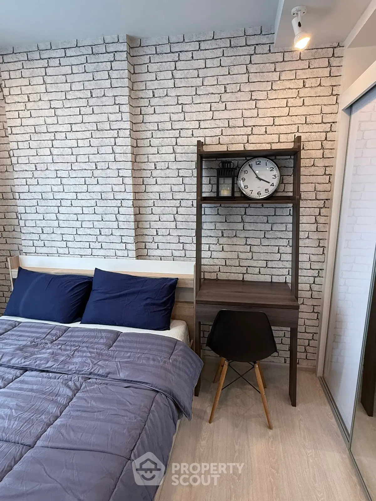 Modern bedroom with stylish brick wall and cozy workspace