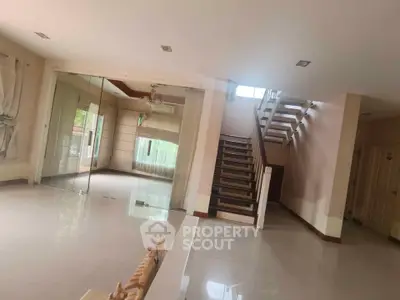 Spacious modern living room with staircase and large windows for natural light