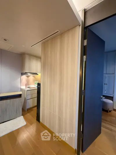 Modern apartment interior with wooden flooring and sleek kitchen design