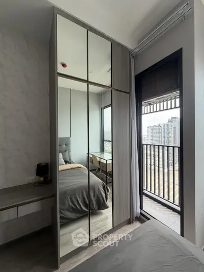 Modern bedroom with mirrored wardrobe and city view balcony in high-rise apartment