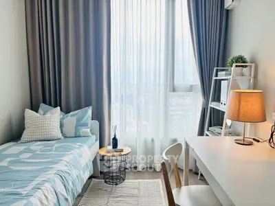 Cozy bedroom with modern decor and large window offering natural light and city view.
