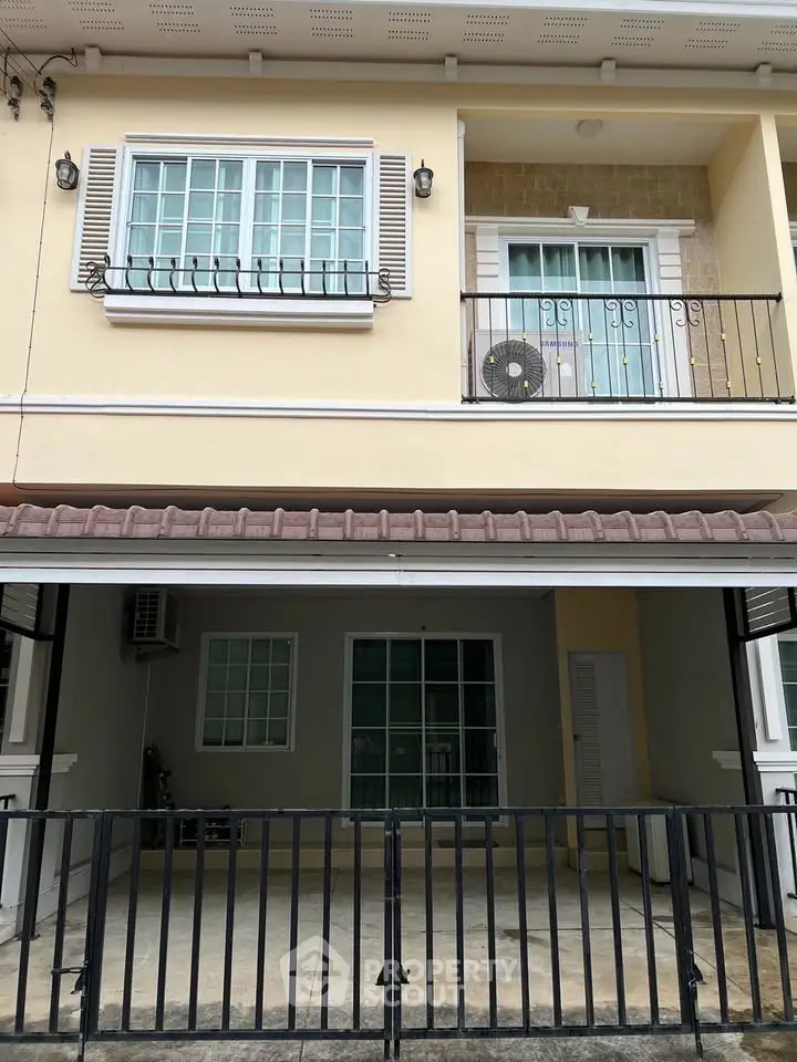 Charming two-story townhouse with gated parking and stylish exterior design.