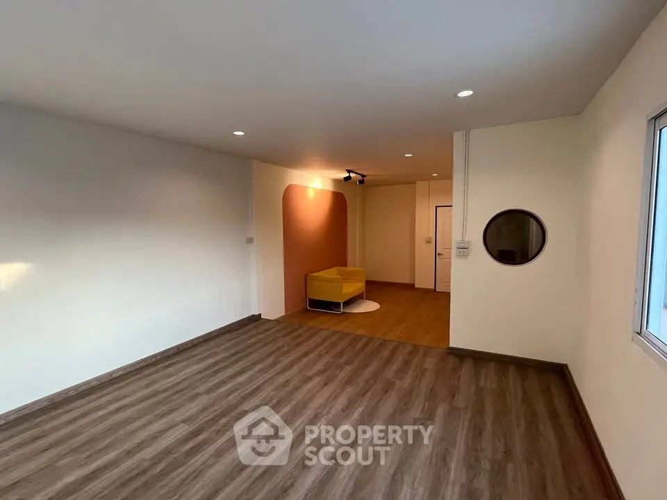 Spacious modern living room with wooden flooring and stylish lighting