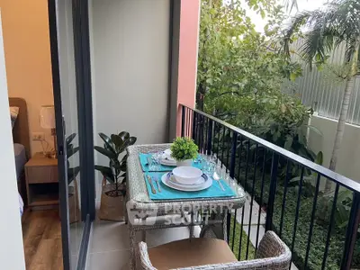 Charming balcony with cozy dining setup and lush garden view, perfect for relaxation.