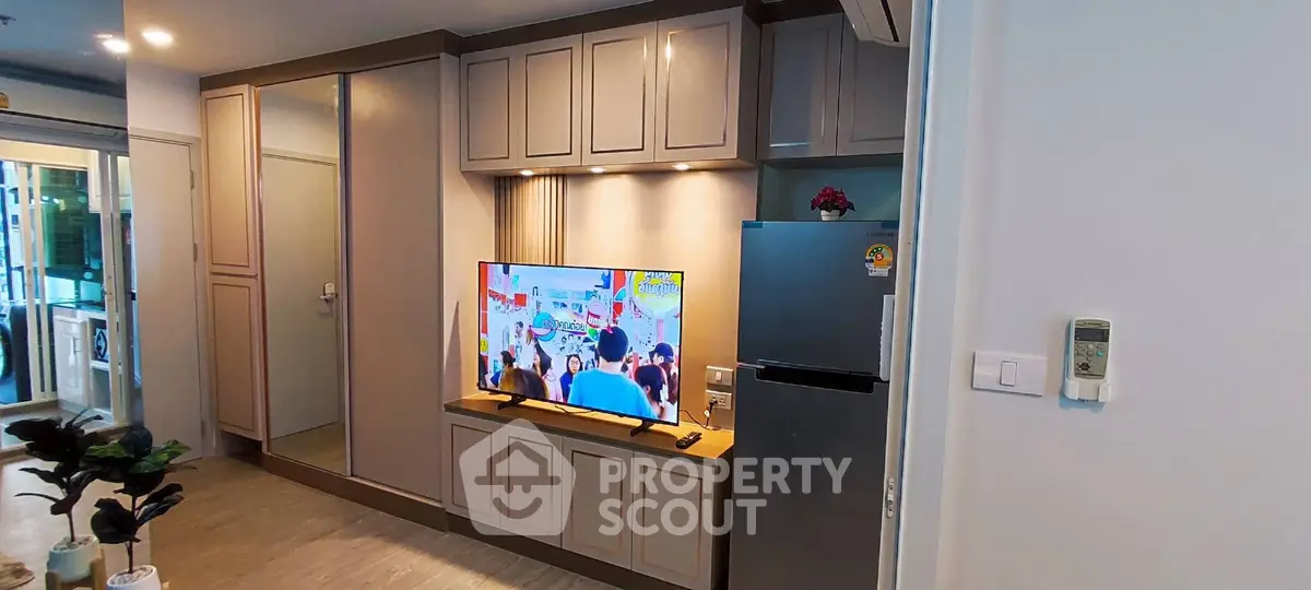 Modern living room with built-in cabinets and flat-screen TV, showcasing sleek design and functionality.
