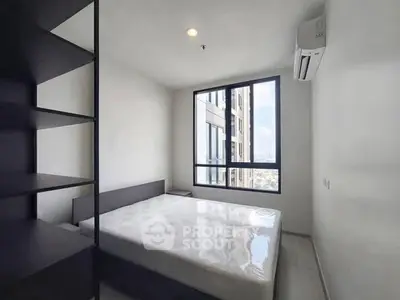 Modern minimalist bedroom with large window and city view