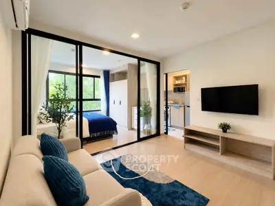 Modern living room with open layout and stylish decor, featuring a cozy sofa and wall-mounted TV.