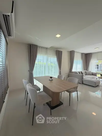 Spacious modern living room with elegant dining area and large windows.