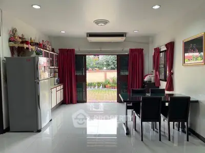 Spacious kitchen with dining area and garden view, featuring modern appliances and elegant decor.