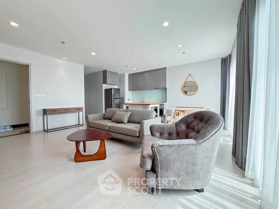 Spacious modern living room with stylish furniture and large windows in a contemporary apartment.