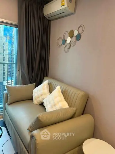 Cozy living room with modern sofa and stylish wall decor, featuring a city view from the window.