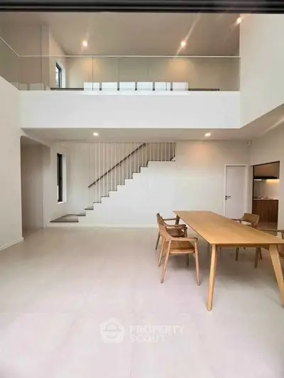 Spacious modern living room with high ceiling and elegant staircase