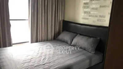 Modern bedroom with stylish decor and large window for natural light.